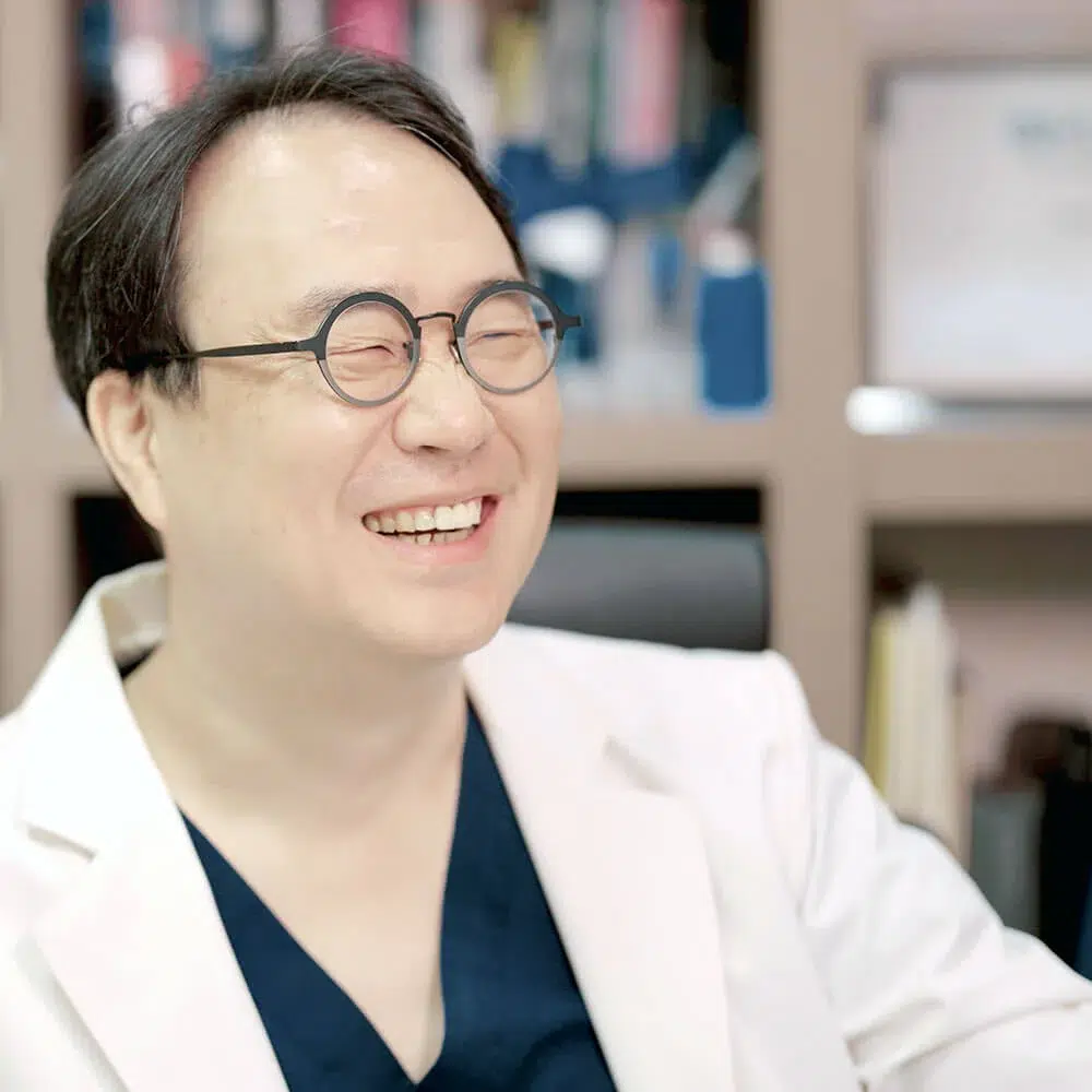 dr-francis-jeon-clinic-consultation Dr. Francis Jeon, MD, smiling during a consultation at Evita Clinic in Seoul, providing care for international patients.