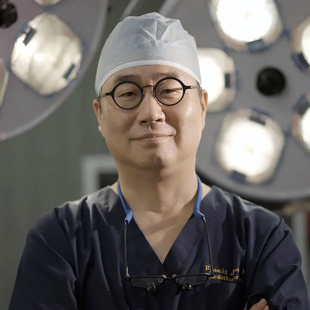 dr-francis-jeon-md-evita-clinic Dr. Francis Jeon, MD, board-certified thoracic and cardiovascular surgeon and medical director of Evita Clinic, wearing surgical scrubs in an operating room.